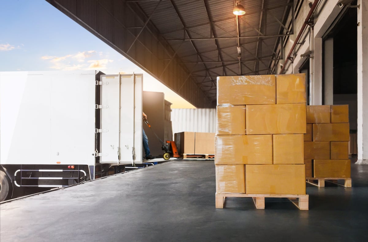 Wrapped pallets of goods being loaded into a freight container